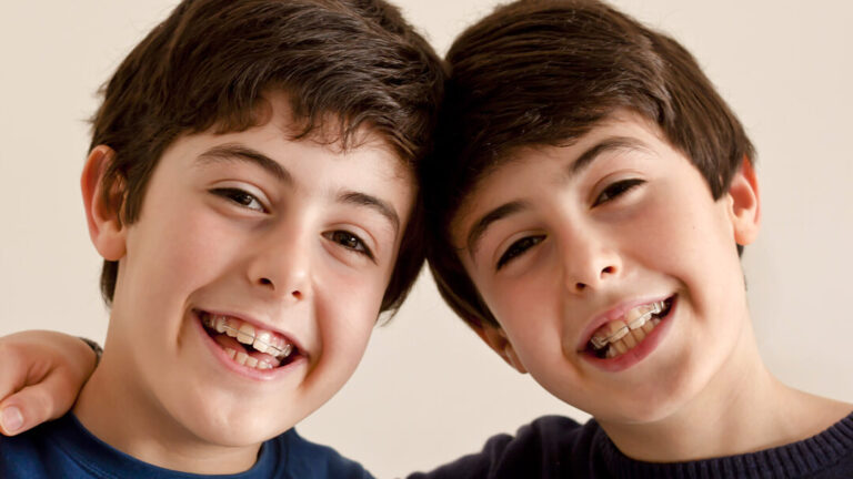 Smiling twins with orthodontic appliances at Blackburn Orthodontics